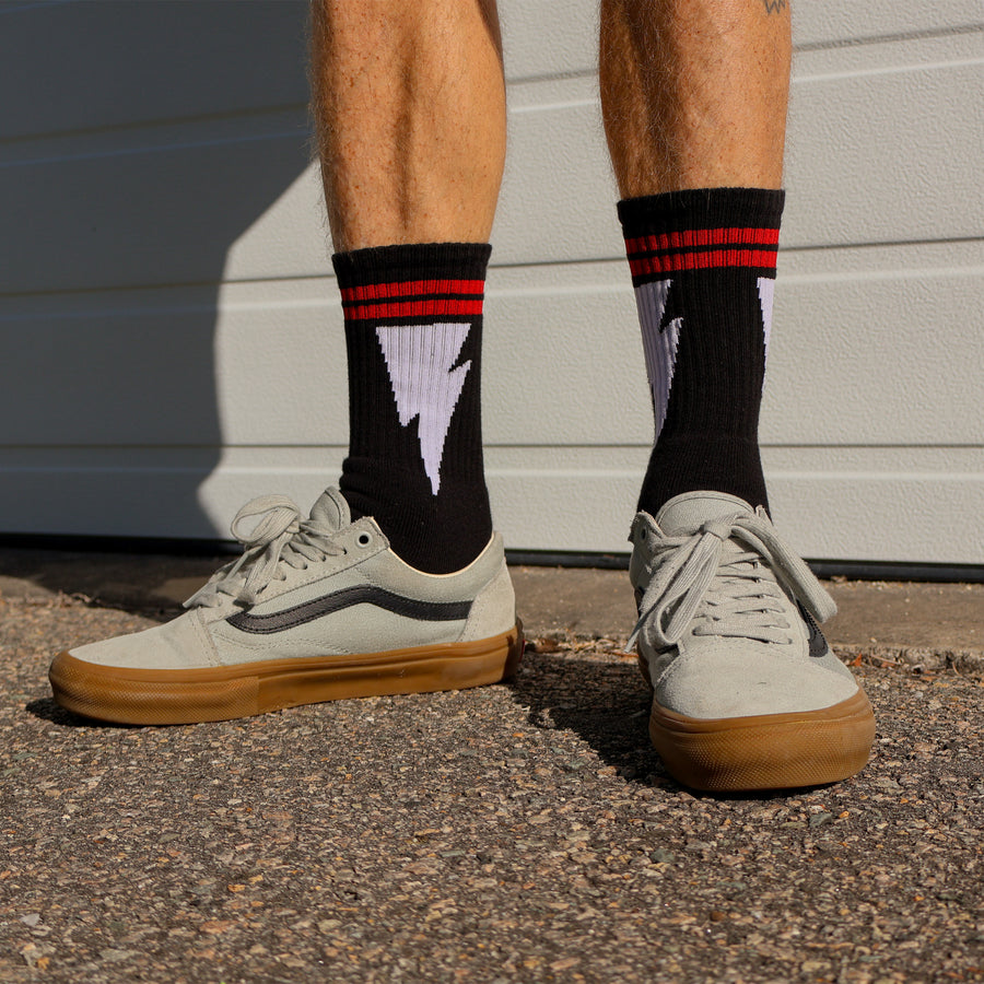 Male wearing Black Mike Vallely Organic Lightning Bolt Socks with Red Stripes