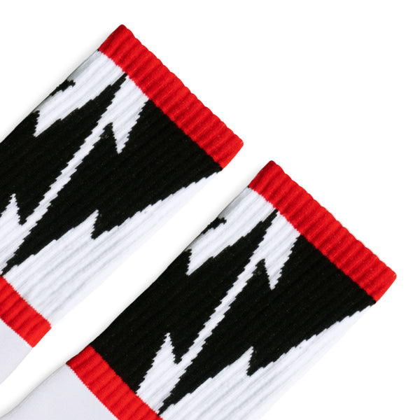 White Crew socks with Large Black Lightning Bolts decorating the leg all the way around in between two thin red stripes. Mike Vallely's Signature knitted into the bottom of the foot.