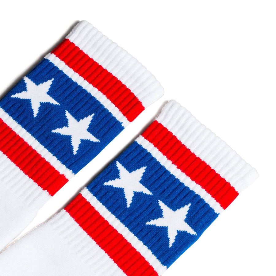 White athletic socks with two red stripes and white stars on a thick blue stripe for men, women and kids.