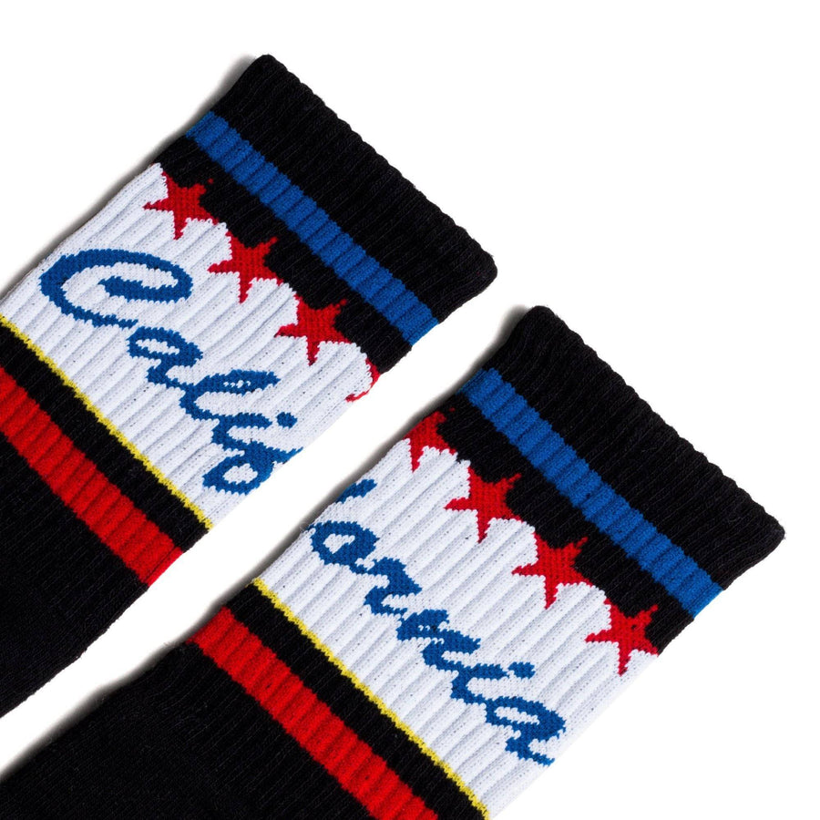 Black athletic socks with California text in blue cursive over white and red and blue stripes. Crew Socks for Men, Women, and Children.