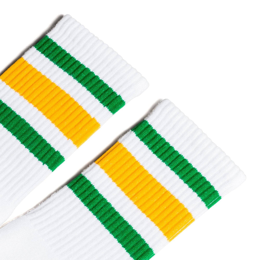 White athletic crew length socks with green and gold stripes for men, women and children.