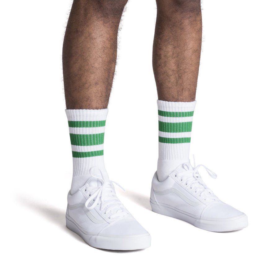 White athletic crew length socks with three green stripes for men, women and children.