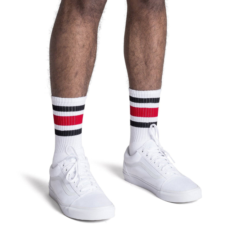 White athletic socks with black and red stripes on the leg. Made for men, women and children. Crew Sock Length.