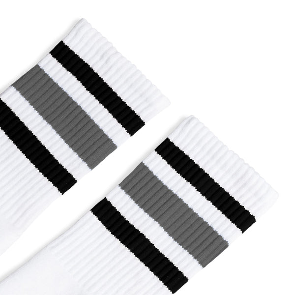 White athletic socks with black and grey stripes on the leg. Made for men, women and children. Crew Sock Length.