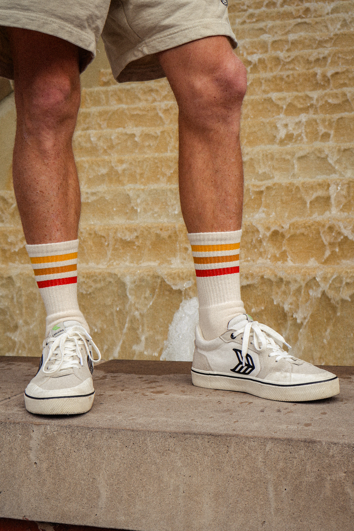 Male wearing sunset stripes SOCCO socks.