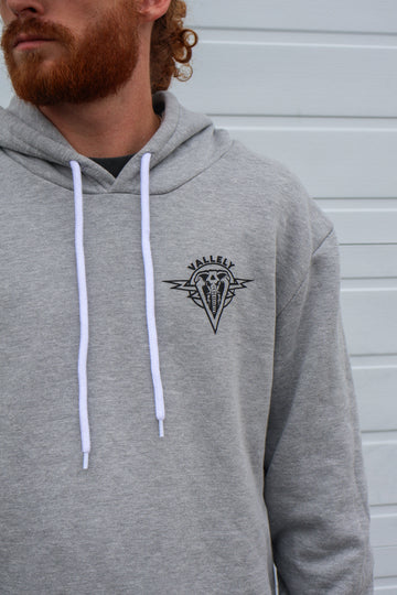 Close up of heather gray Dirty Donny x Mike Vallely Collaboration Logo Hoodie with White Pull Strings and Black logo on the front left chest area.