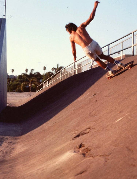 Skateboarder in SOCCO socks skating concrete wave.