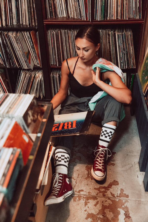 Female wearing white with black checkered SOCCO socks.