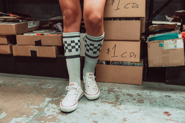 Female wearing grey with black checker SOCCO socks.