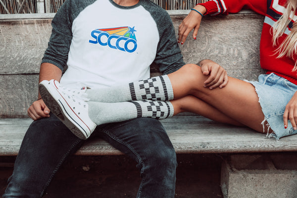 Female wearing grey with black checker SOCCO socks.