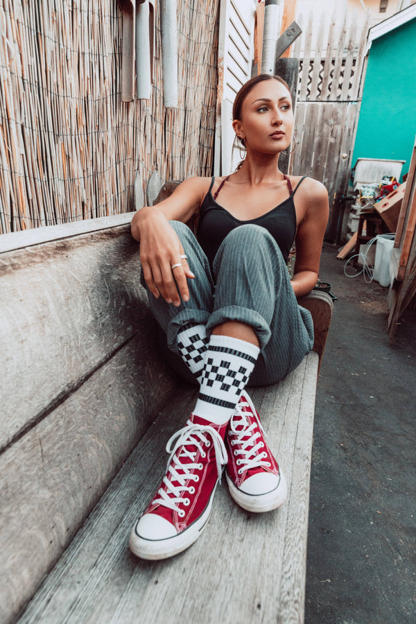 Female wearing white with black checkered SOCCO socks.