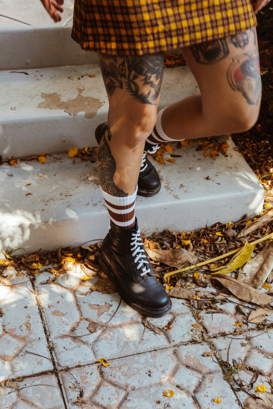 Blonde female wearing brown striped SOCCO socks with Doc Martens Boots