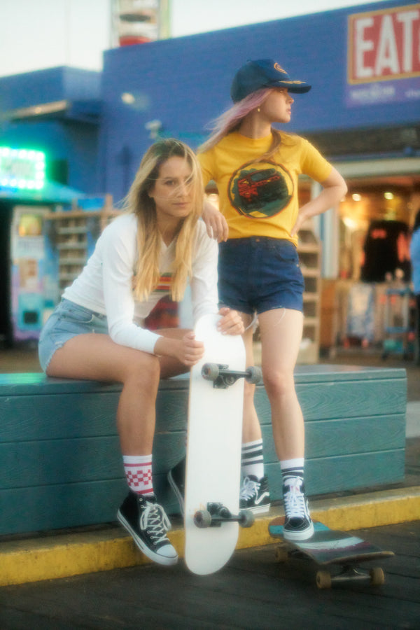 Female skateboarder wearing red checkered SOCCO socks.