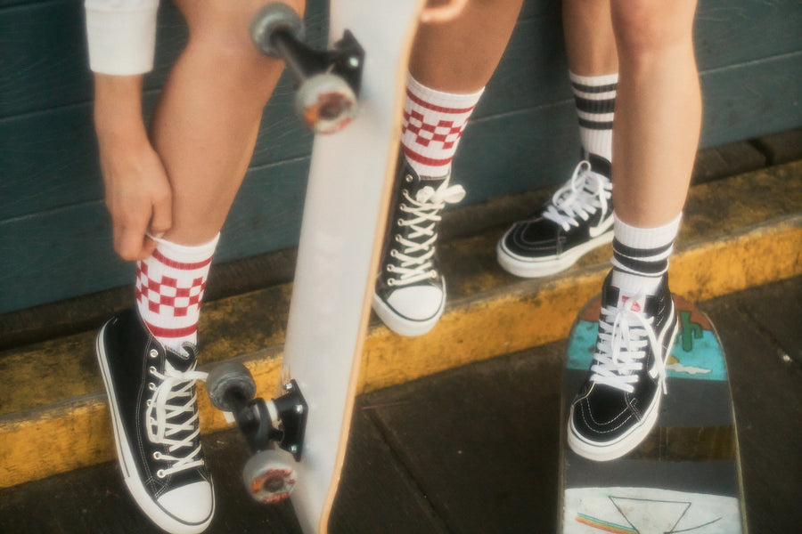 Female skateboarder wearing red checkered SOCCO socks.