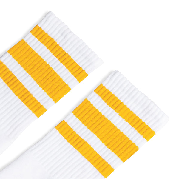 White athletic crew length socks with three gold stripes for men, women and children.