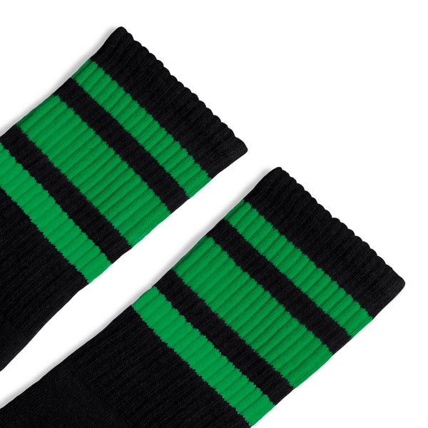 Black athletic crew length socks with three green stripes for men, women and children.