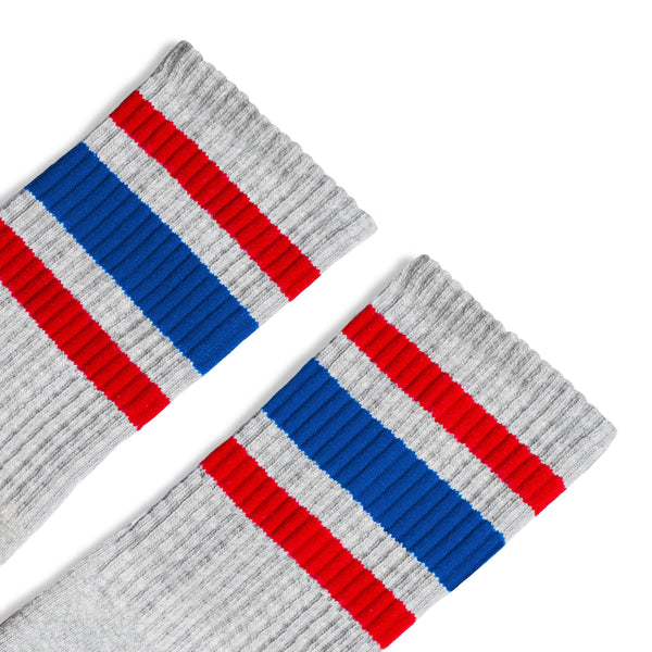 Grey athletic tube socks with red and blue stripes. Gray color.