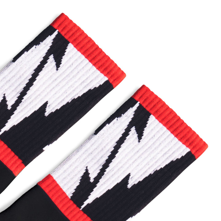Black Crew socks with Large White Lightning Bolts decorating the leg all the way around in between two thin red stripes. Mike Vallely's Signature knitted into the bottom of the foot.