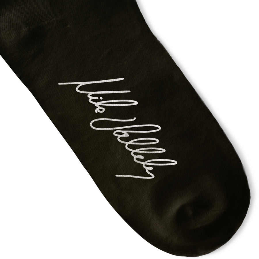 Black Crew socks with Large White Lightning Bolts decorating the leg all the way around in between two thin red stripes. Mike Vallely's Signature knitted into the bottom of the foot.