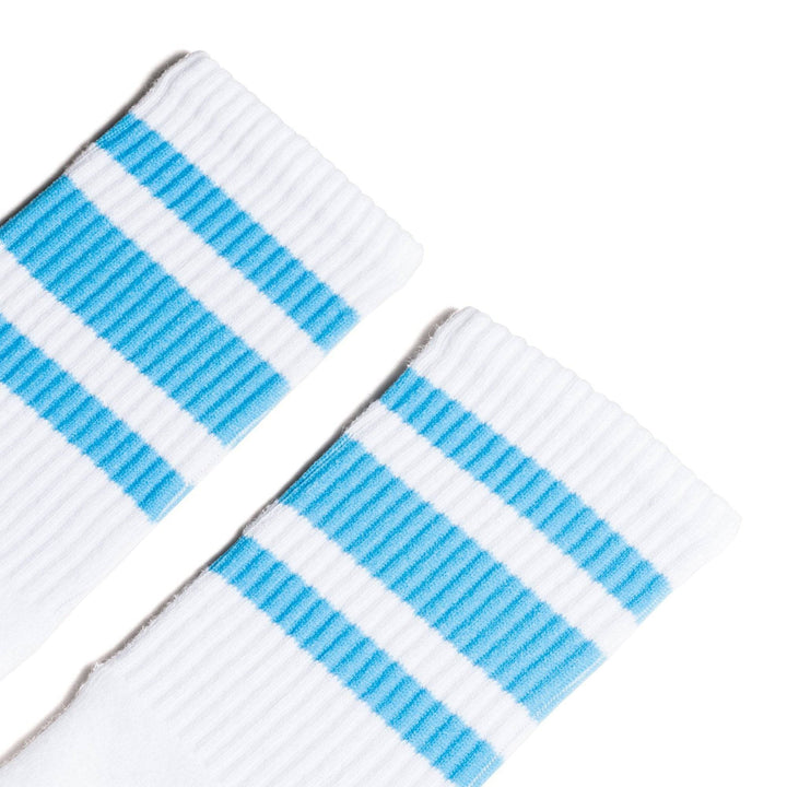 White athletic socks with three Carolina blue stripes. Crew Length Socks for men, women and kids.