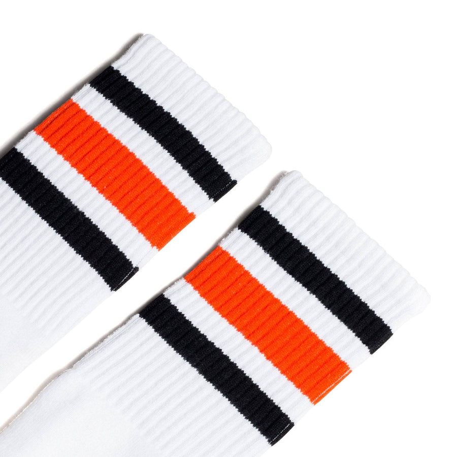 White athletic socks with black and orange stripes on the leg. Made for ...