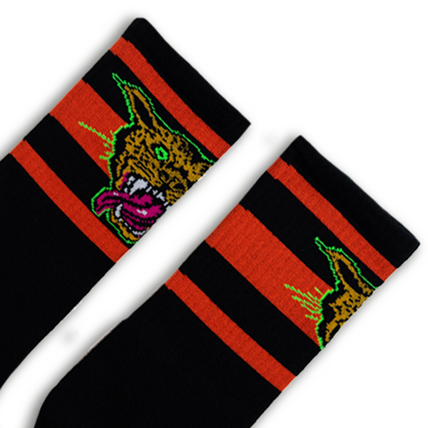 SOCCO x Dirty Donny Cougar Socks. Black Crew socks with three red stripes on the leg; on top of the stripes on the outside of the leg is a 70s style Cheetah head with it's mouth open, teeth bared, and tongue hanging out. The Cheetah is outlined in Acid Green. Dirty Donny Logo Signature on the top of the foot is in white.