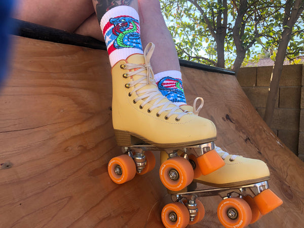 SOCCO x Dirty Donny Cobra Socks. White Crew Socks with three stripes: the top is red, the middle is light blue with white stars, and the bottom is red. 70s style Blue Star Spangles Body with Stripes inside the snake's hood, and an acid green belly. Dirty Donny Logo Signature on the top of the foot.